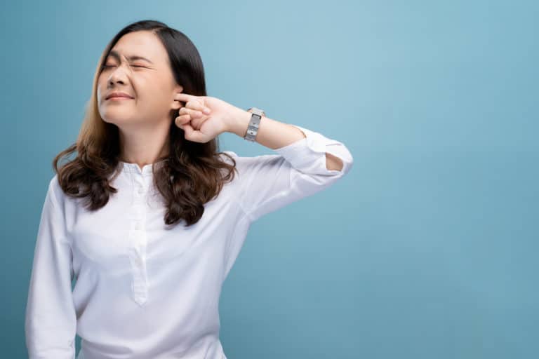 Woman putting finger in ear