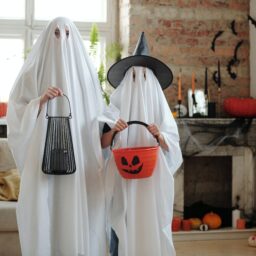 Parent and child dressed as ghosts for Halloween.