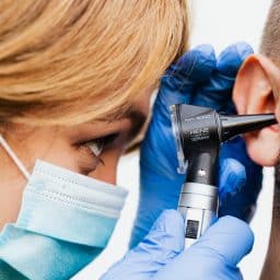 Close up of doctor examining a man's ear.