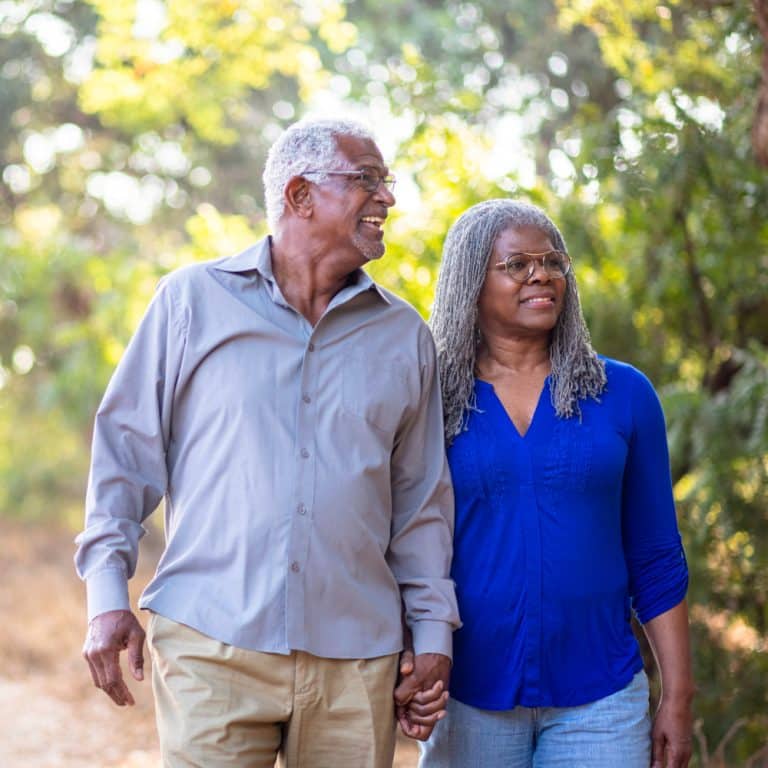 a couple holds hands while walking