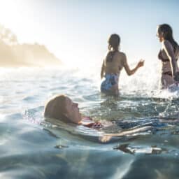 Three young kids swimming at the beach