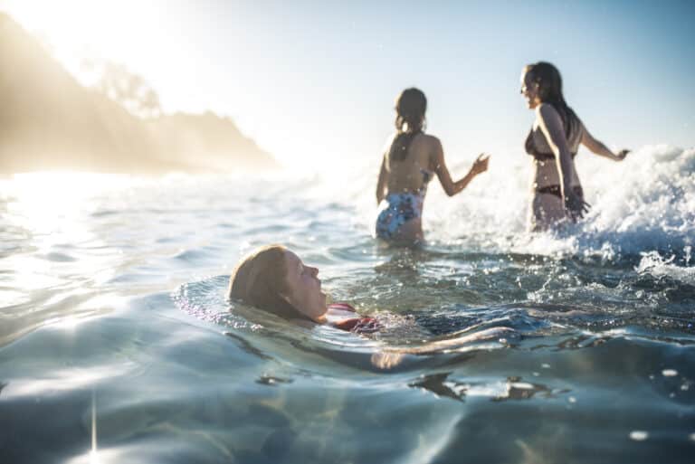 Three young kids swimming at the beach