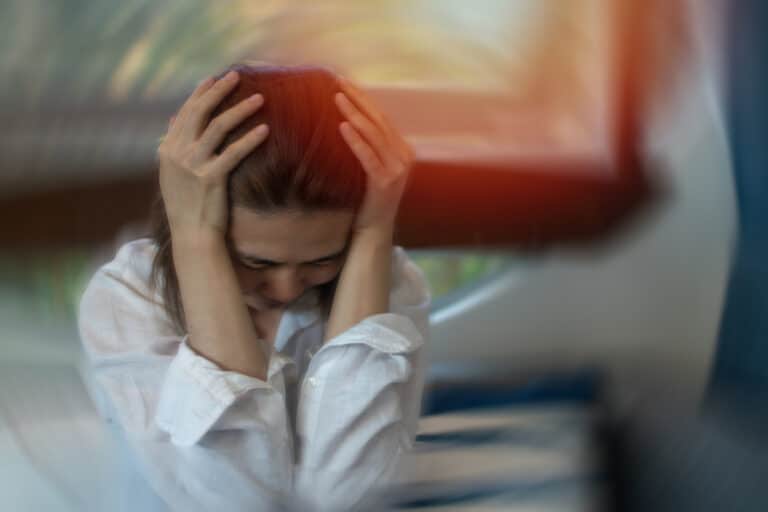 Woman with tinnitus holding her head 