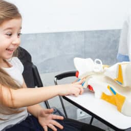 Young girl pointing at a model of an ear in their doctor's office