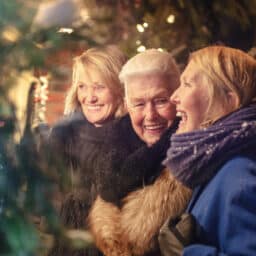 Happy senior women laughing together during winter shopping