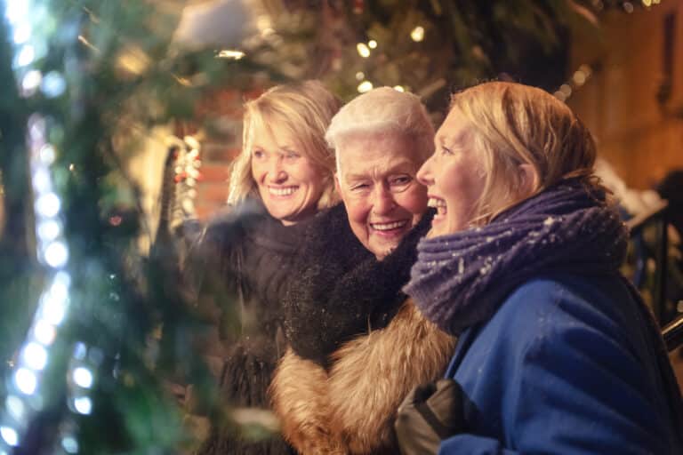 Happy senior women laughing together during winter shopping