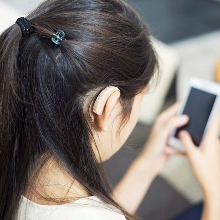 Woman with hearing aids using her hearing aid bluetooth app